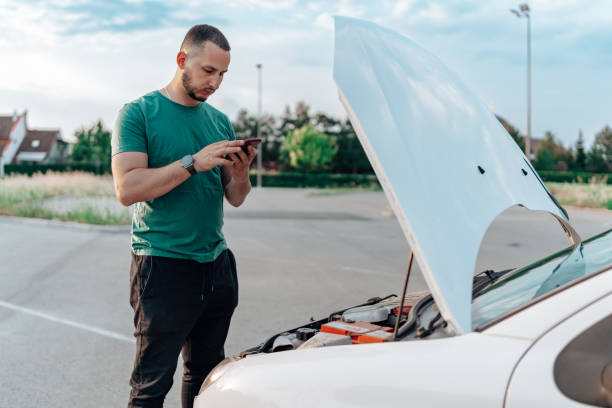 istock Stranded with a malfunctioning car, the young man urgently dials for assistance on his mobile phone 1661398312