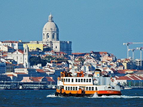 Lisbon, Portugal - May 1, 2022: A passenger craft crosses the Tagus River in Lisbon.