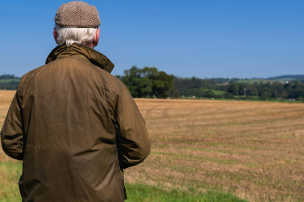 istock Retired man looking at a recently harvested field 1661412183