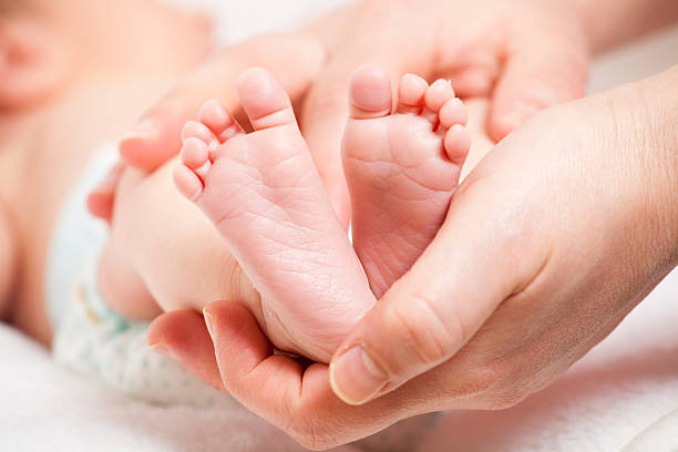 istock baby feet in mother's hands 166141389