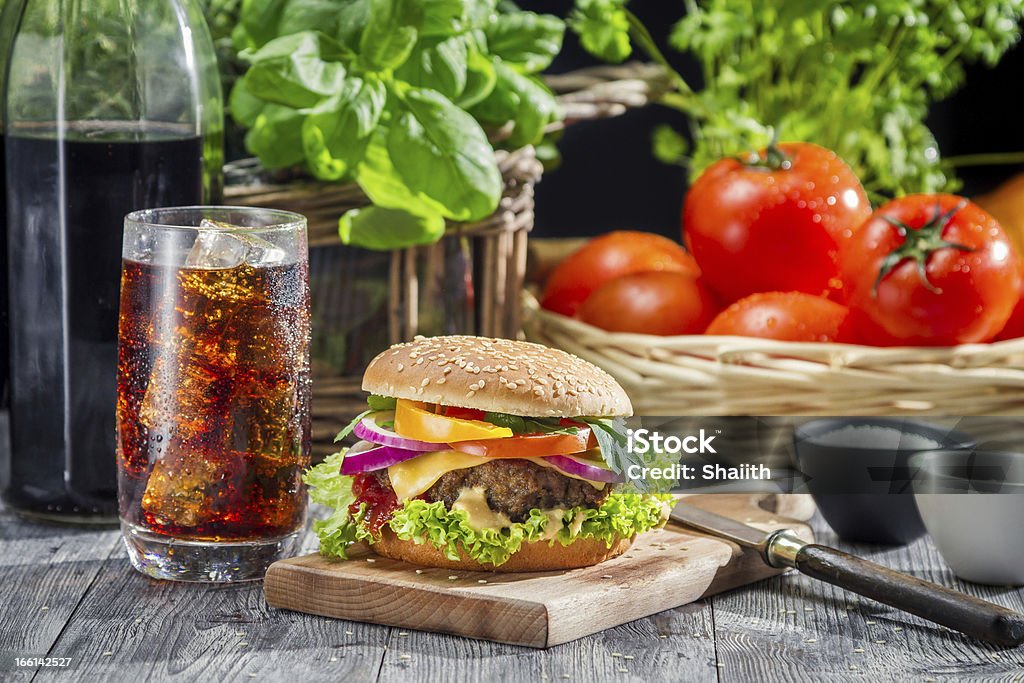 hamburger fatti in casa e una Coca-Cola con ghiaccio - Foto stock royalty-free di Alimentazione non salutare