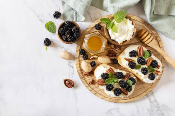 kanapki z dietą ketonową, przekąski. słodka bruschetta z serem i jagodami, jeżyną, ricottą i miodem na marmurowym stole. zdrowe tosty śniadaniowe. widok z góry. przestrzeń kopiowania. - toast bread berry appetizer zdjęcia i obrazy z banku zdjęć