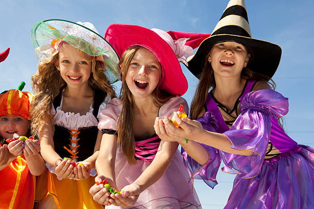 cuatro halloween girls holding golosinas. - costume stage costume sunlight carnival fotografías e imágenes de stock