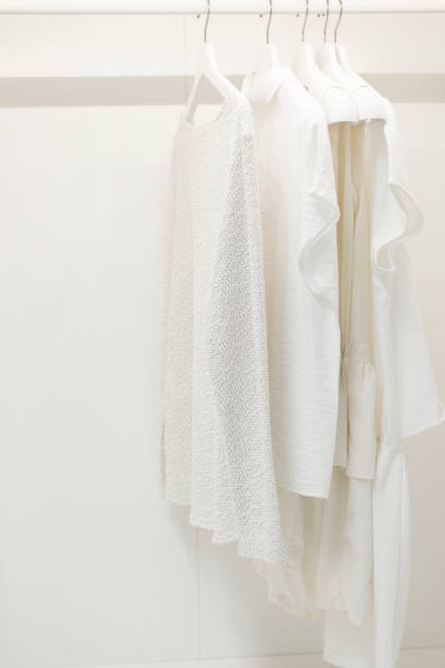 istock Women's clothes hanging on a rail in a white room 1661429291