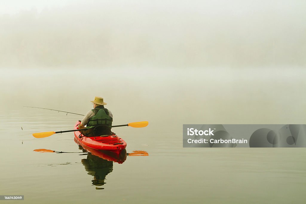 Pescatore in Rosso kayak, la nebbia mattutina, riflesso - Foto stock royalty-free di Kayak