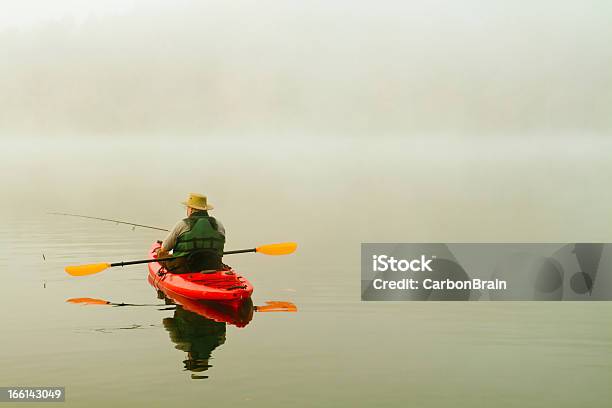 Pescatore In Rosso Kayak La Nebbia Mattutina Riflesso - Fotografie stock e altre immagini di Kayak