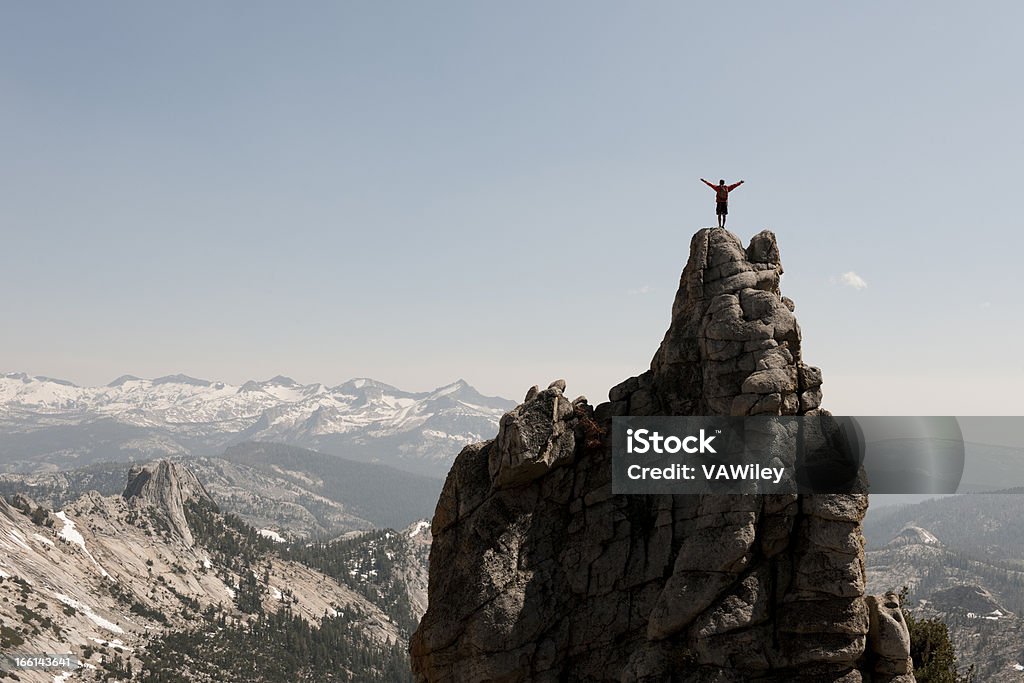 peak A man with his arms raised on a mountain  Activity Stock Photo