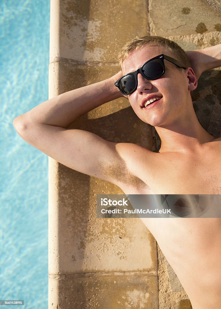 Joven relajante junto a la piscina con gafas de sol - Foto de stock de Adolescente libre de derechos