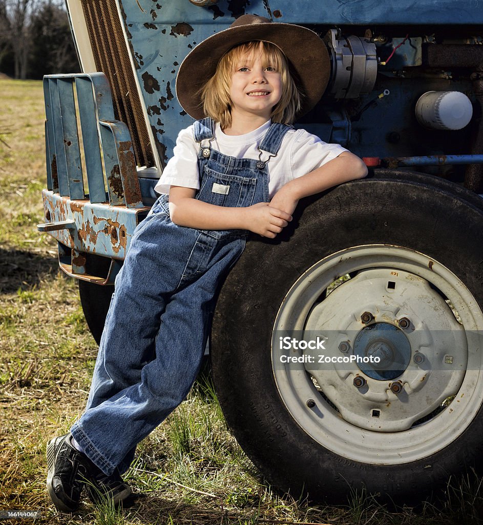 Jeune garçon avec un tracteur - Photo de Agriculteur libre de droits