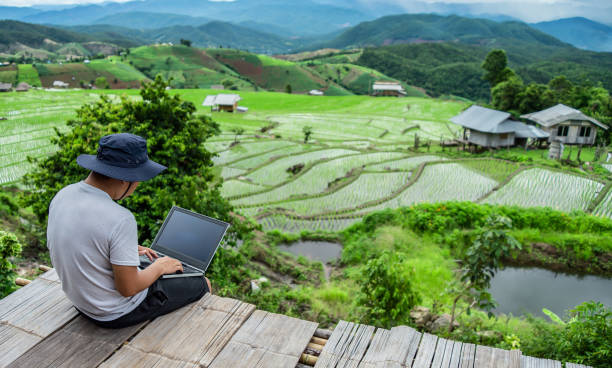 A competent freelancer typing on a laptop while a talented male digital nomad creates a tour guide to the high mountains for sharing with followers on social networks connected to 4G internet.