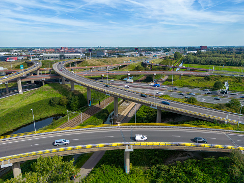 Aerial view of traffic and overpasses, city skyline on the horizon.