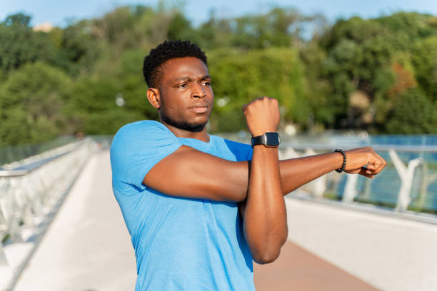 istock Muscular African American man warming up, doing exercises, stretching before running on the street 1661468805