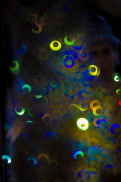 istock Brightly colored spheres of light sparkle against a dark black background. 1661474470