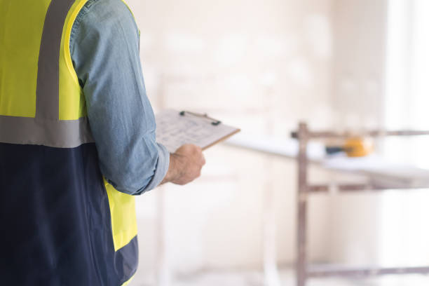 istock Professional engineer holding clipboard with plan of house interior renovation in hands 1661474473