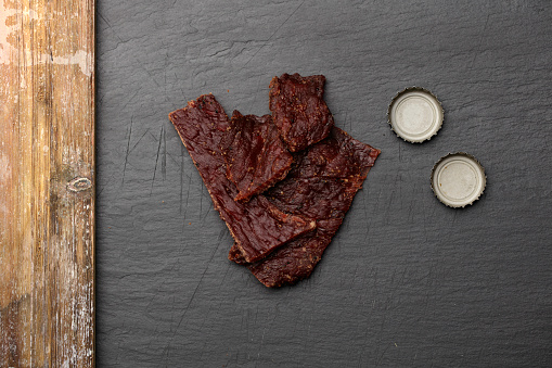 Strips of beef jerky  on a slate serving platter