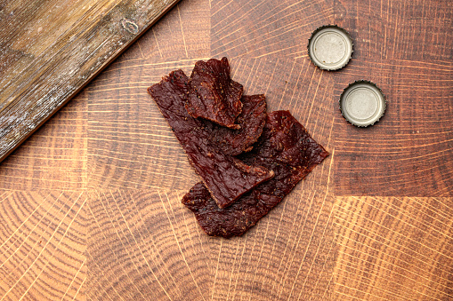 Strips of beef jerky  on a wood serving platter