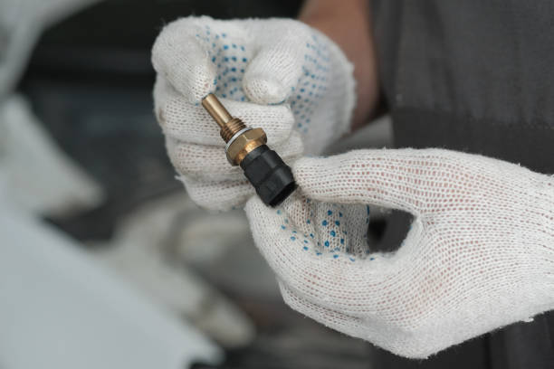 istock An auto mechanic holds a new temperature sensor of an automobile engine in his hands. 1661481642