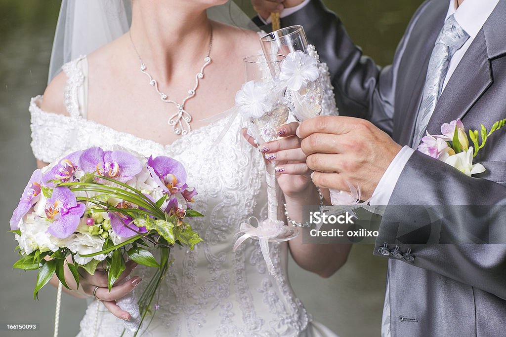 Copas de bodas en las manos del novio y la novia - Foto de stock de Amor - Sentimiento libre de derechos