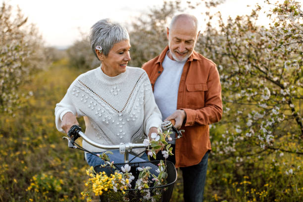 istock Active senior couple enjoying bicycle ride through cherry tree orchard 1661517577