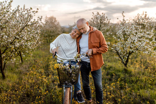 istock Active senior couple enjoying bicycle ride through cherry tree orchard 1661518184