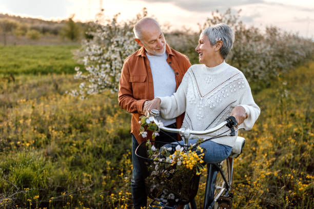 istock Active senior couple enjoying bicycle ride through cherry tree orchard 1661518185
