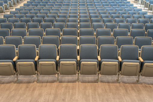 Empty gray and blue theater, auditorium seats, chairs.