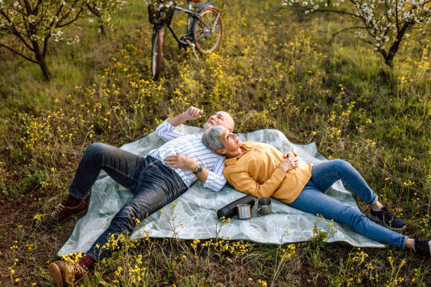 istock Senior couple resting on a picnic blanket in nature. 1661520263