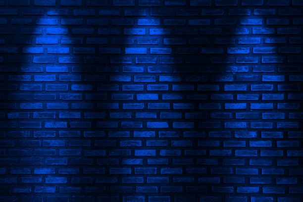 istock Three blue neon bulbs on a black brick wall empty black wall   with glow style blue neon light. background texture 1661530403