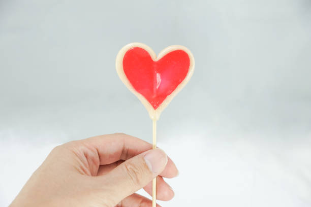 istock Hand holding Valentine's lollipop heart-shaped 1661549634