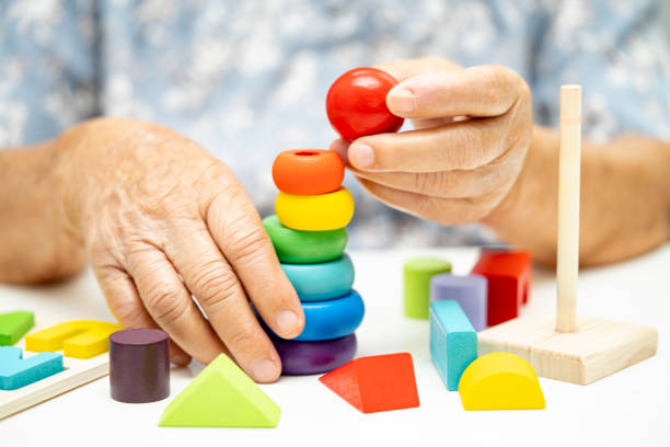 istock Alzheimer disease AD, Asian elderly woman patient suffering from dementia learn practical motor skills rehabilitation. 1661564738