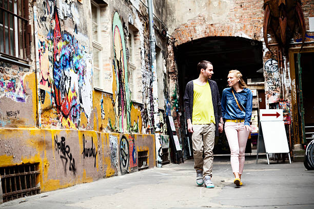 Young couple walking in a graffitied alley