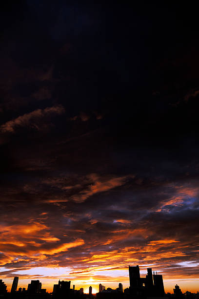 istock Cloudy Sunset over Urban Skyline Silhouette 166158098