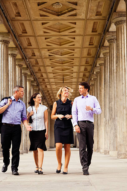 istock Four Elegant People Walking in Columns Passage 166158615