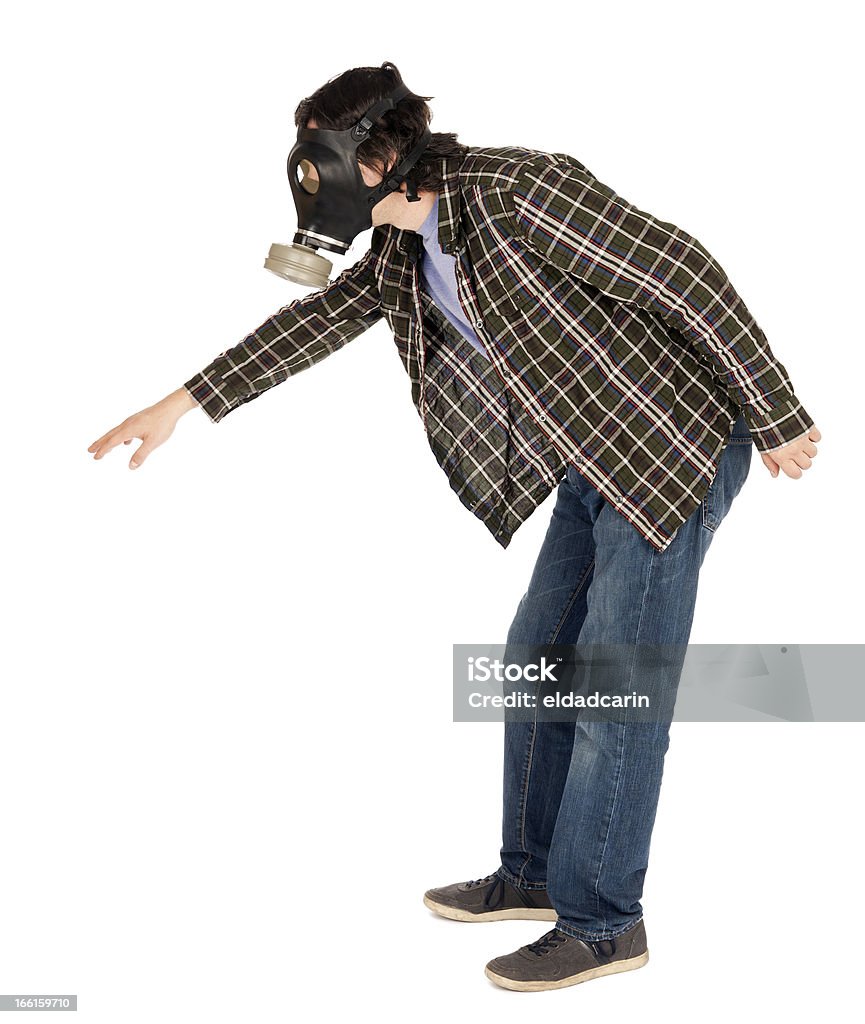 Isolated Man Wearing Gas Mask and Reaching A caucasian male in his early 30's dressed in a casual attire and wearing a gas mask, trying to reach something, leaning towards it. Isolated on white background. Gas Mask Stock Photo