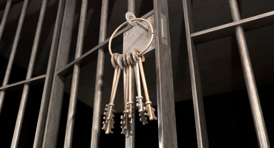 Ring of keys hanging from a slightly ajar jail cell door