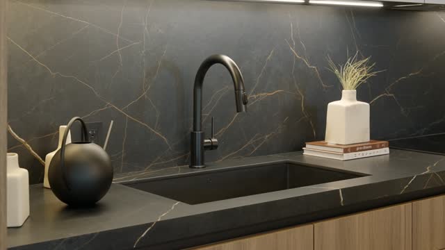 Brown kitchen cabinetry with luxurious matte surface crafted from black marble with golden pattern. Integrated sink with sleek faucet and decorative accessories