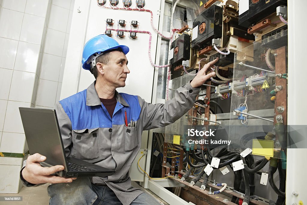 Feliz electricista trabajando en caja de línea de alimentación - Foto de stock de Electricista libre de derechos