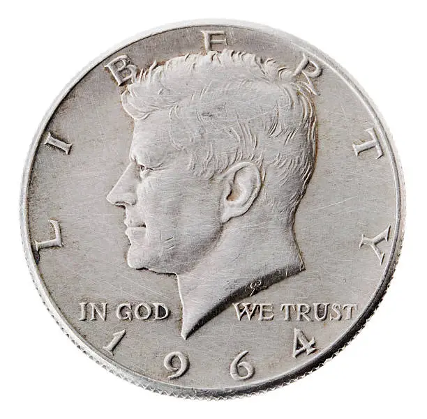 Frontal view of the obverse (heads) side of a silver half Dollar minted in 1964. Depicted is a profile portrait of John F. Kennedy and comes to honor his memory. 
