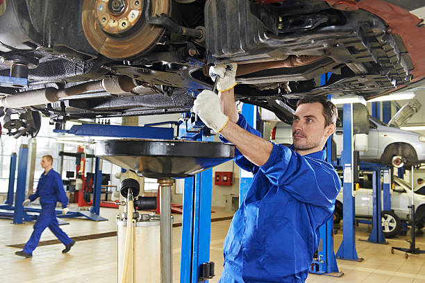 An auto mechanic repairing the suspension on a car stock photo