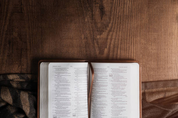 bible on a wooden table, there is an environment of shadows.