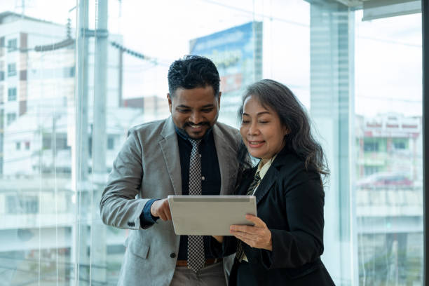 istock Two Business People Working With Tablet in startup office, tow creative work and technology using tablet computer while discussing  in office 1661652612