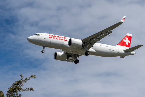 Swiss Airbus A320 landing at London Heathrow Airport on a beautiful sunny day.