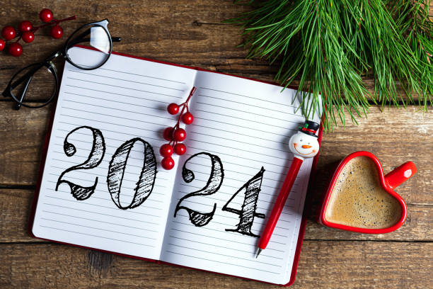 istock New year resolutions 2024 on desk. 2024 resolutions list with notebook, coffee cup on wooden table. Goals, resolutions, plan, action, checklist concept. New Year 2024 template 1661677995