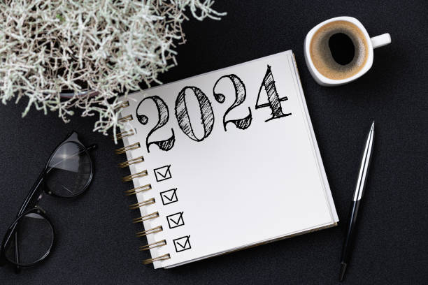 istock New year resolutions 2024 on desk. 2024 goals list with notebook, coffee cup, plant on black table. Resolutions, plan, goals, action, checklist, idea concept. New Year 2024 resolutions 1661677996