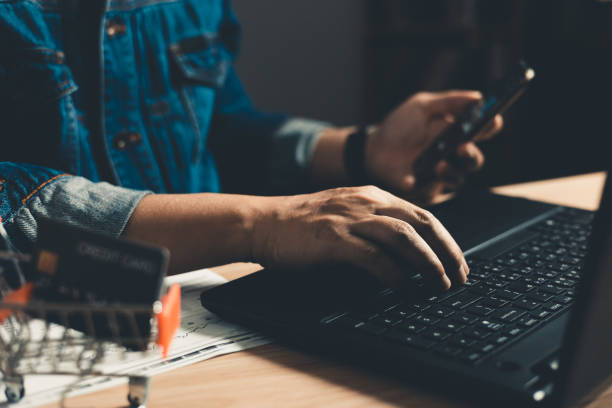 istock Man using smartphone and computer laptop. which is payment online, sits on the chair in the office at home on a desktop. The concept of finance and online shopping. 1661678129