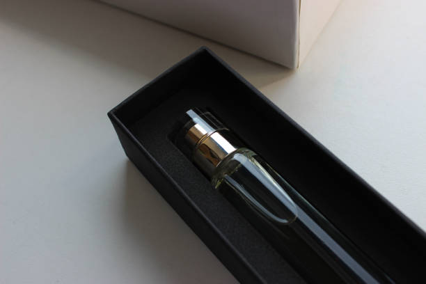 istock Black gift box with perfume near a white cardboard case on a white surface 1661708194