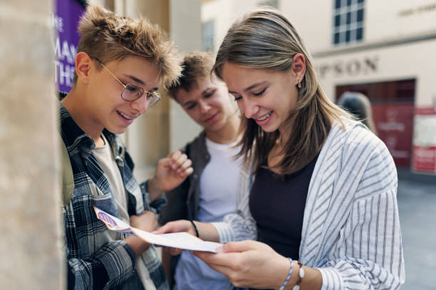 Teenagers checking museum leaflet while sightseeing Bath, Somerset, United Kingdom