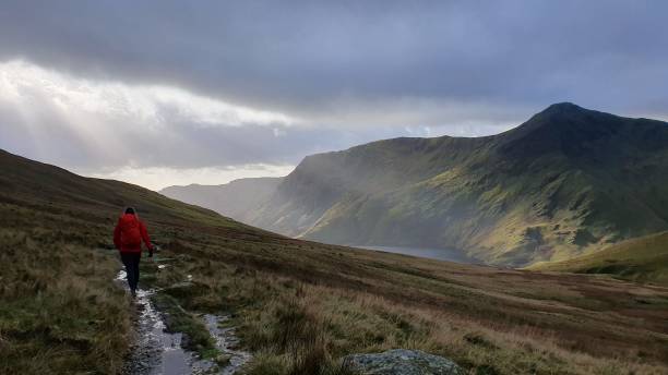istock a person with a backpack walking in the mountains over a path 1661756121