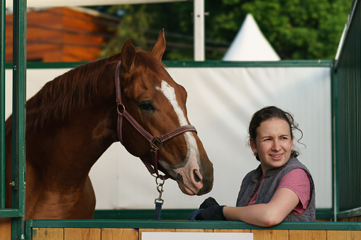 Moscow, Russia - July 8, 2023: Happy horse Riding Coach with purebred Budyonny horse. The Budyonny is a breed of horse from Russia. Street close up photography. Beautiful scene