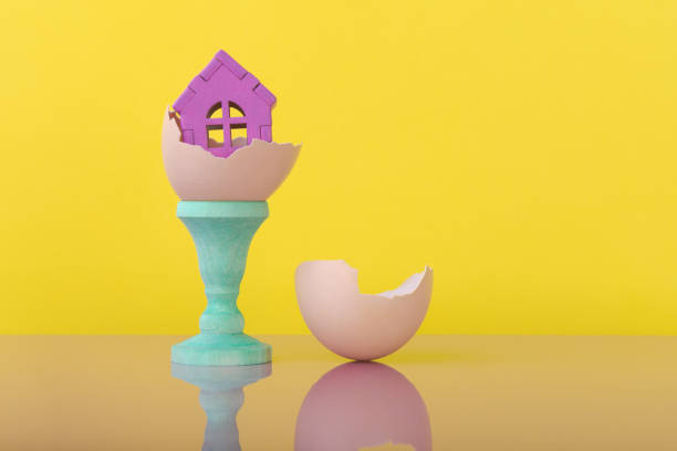 istock House model in eggshell over yellow background with copy space. Conceptual ad for house innovation and new real estate 1661794304